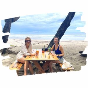 Photo de 2 femmes sur une table de picnic devant la plage du Costa Rica.