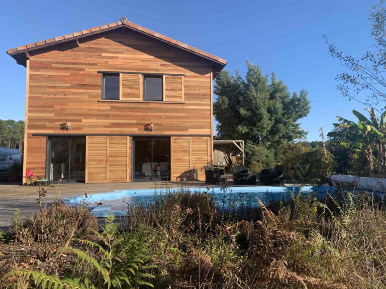 Photo d'une maison avec façade bois et piscine.