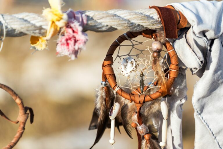 Photo d'un attrape-rêves accroché à une corde avec des fleurs.