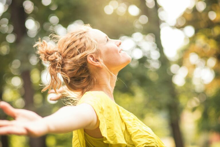 Photo d'une femme bras ouverts dans la forêt.