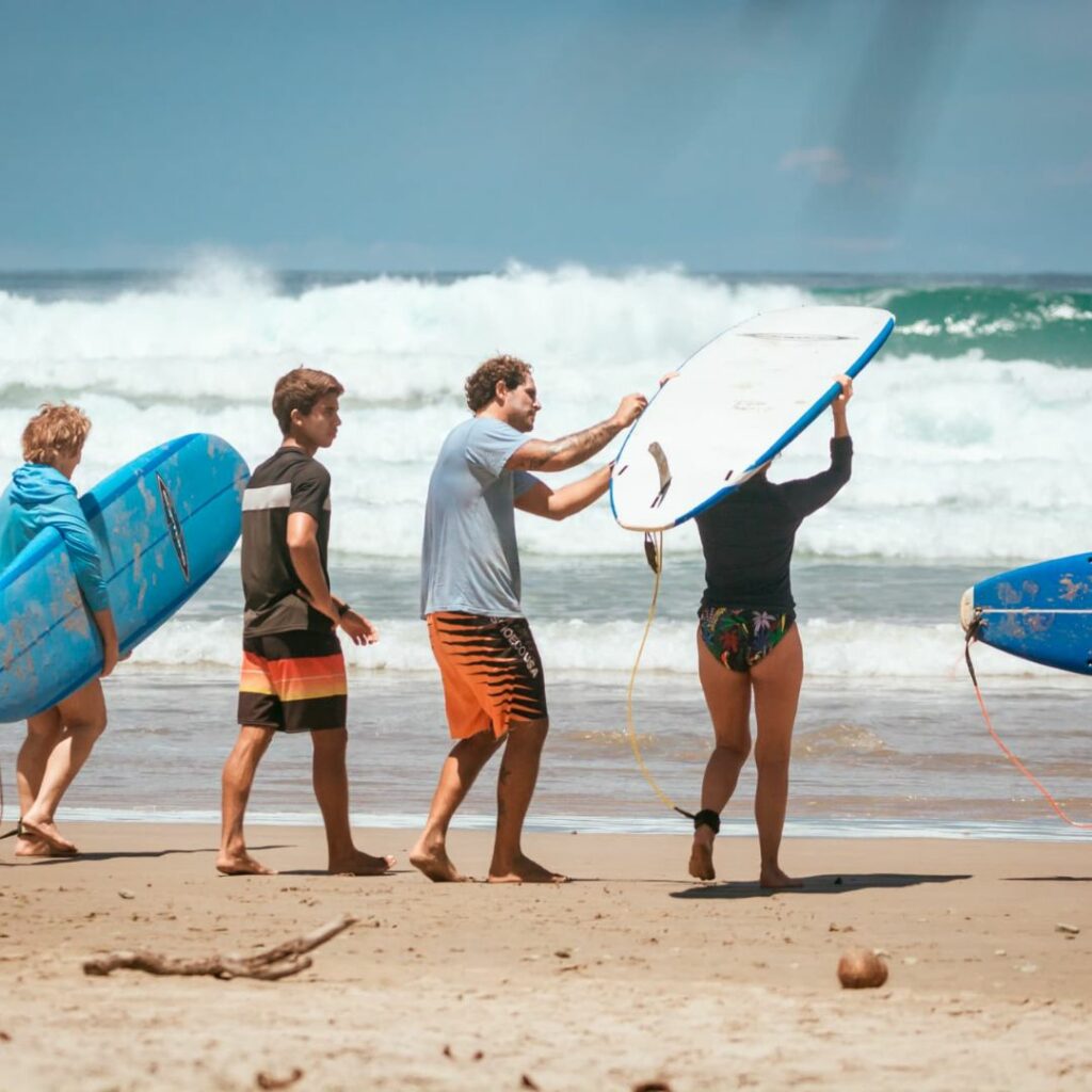 Photo d'un groupe de surf avec leur planche sur la plage.