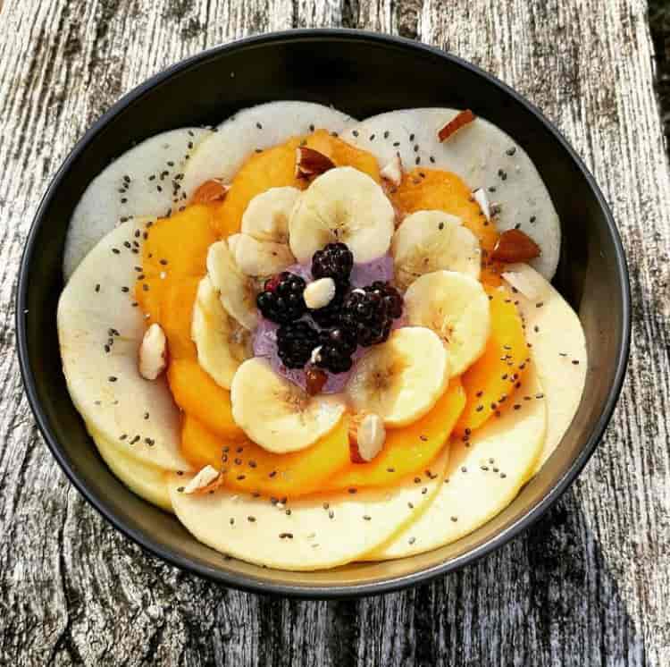 Photo d'une jolie assiette avec des fruits découpés en forme de fleur.
