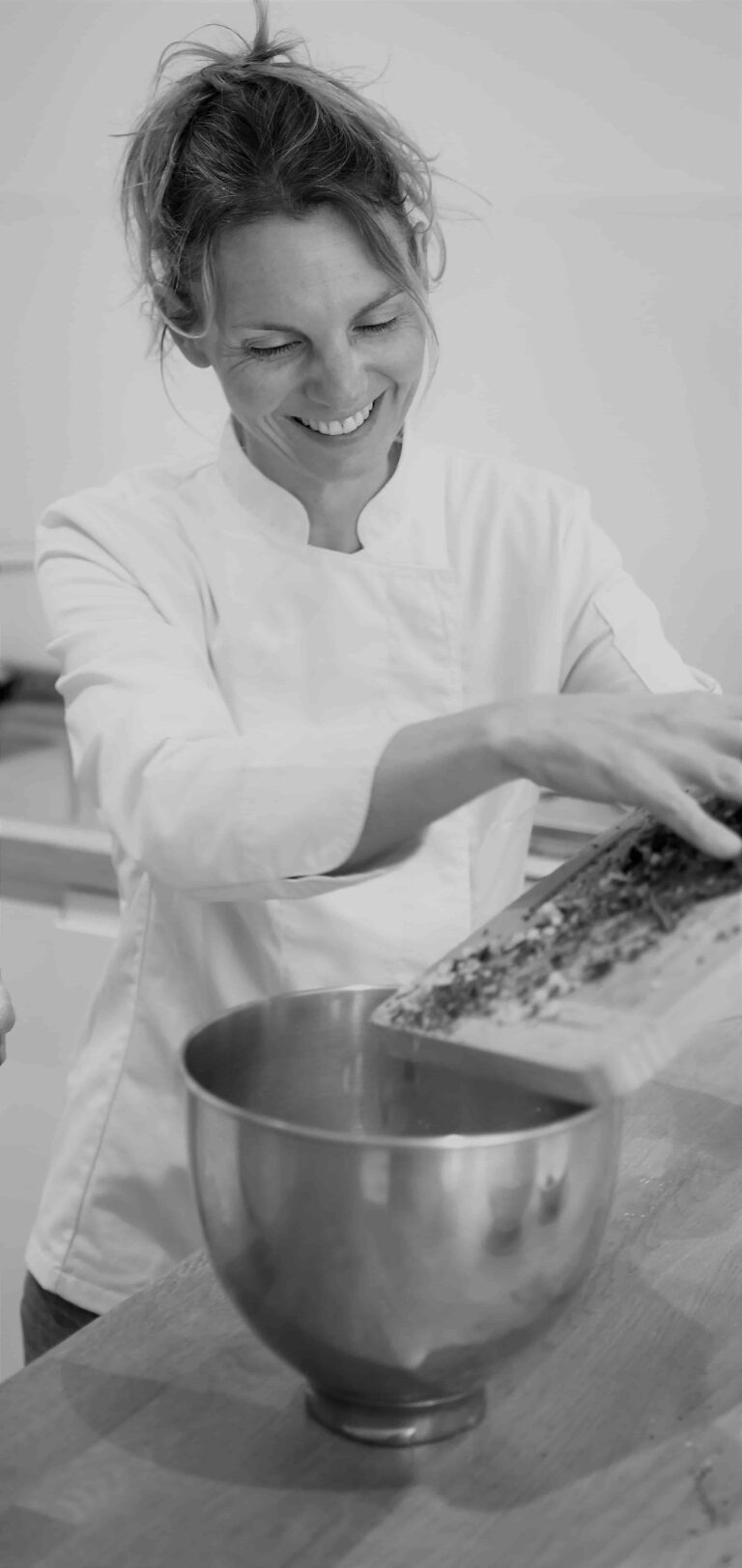 Photo en noir et blanc d'une femme en train de cuisiner.