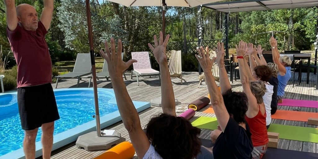 Photo d'un groupe autour d'une piscine en train de faire du yoga.