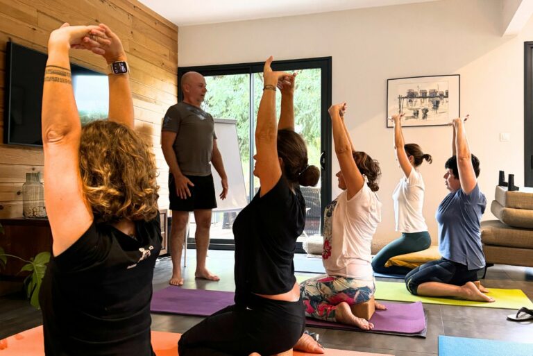 Photo d'un groupe de femmes en train de faire du yoga dans un intérieur de maison.